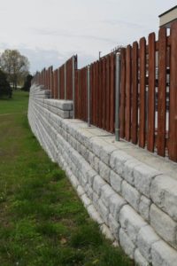 Redi-Rock retaining wall blocks by SI Precast with fencing on top